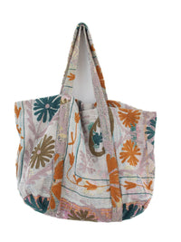 Pastelfarvet, blomsterprintet quiltet tote-taske med orange og blågrønt broderet mønster på blødt cremefarvet stof